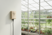 Smart home device on a wall with a greenhouse in the background