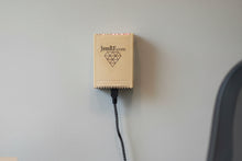 JenRF.com device attached to a wall with a visible power cable.