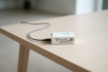 Temperature sensor device on a wooden surface with a blurred background