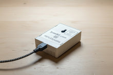 Small electronic device with a USB cable on a wooden surface